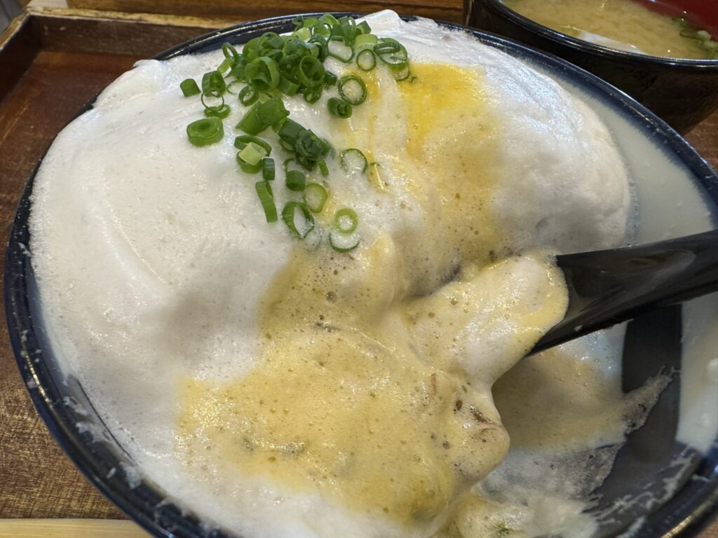 白い漬け丼の卵を割った写真。