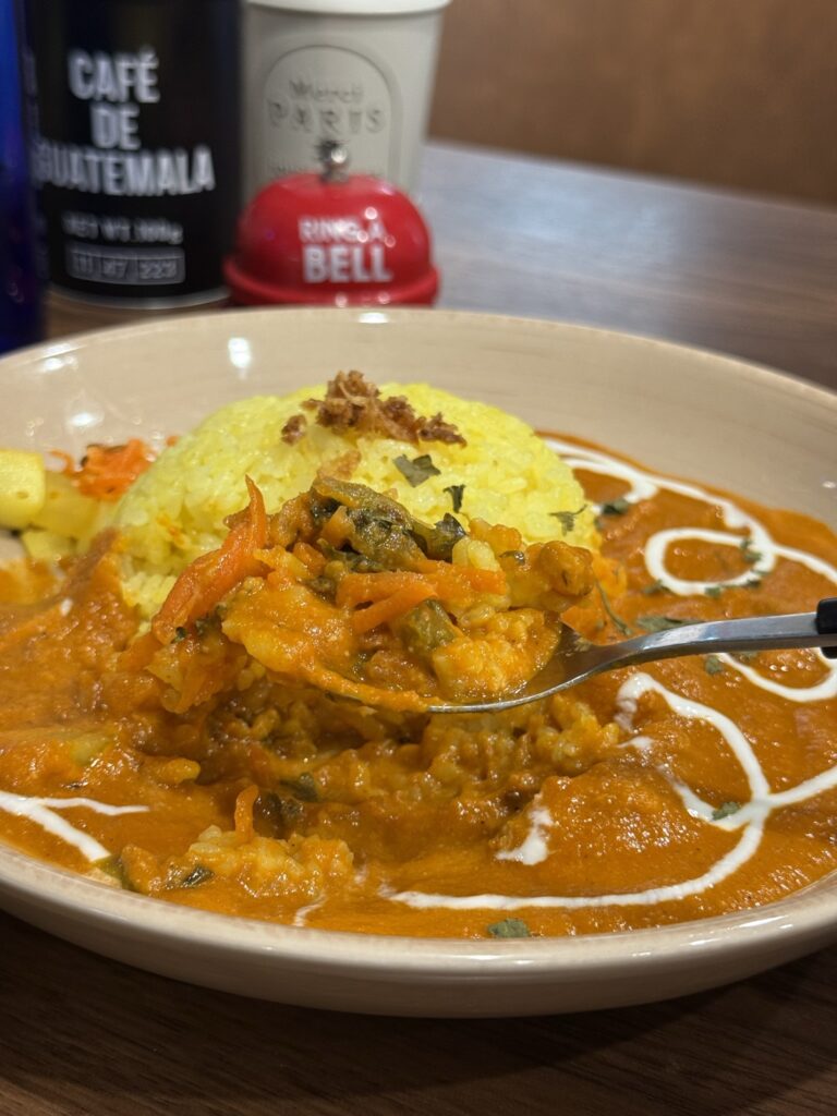 「辛くないバターチキンカレー」のスプーンですくったアップの写真