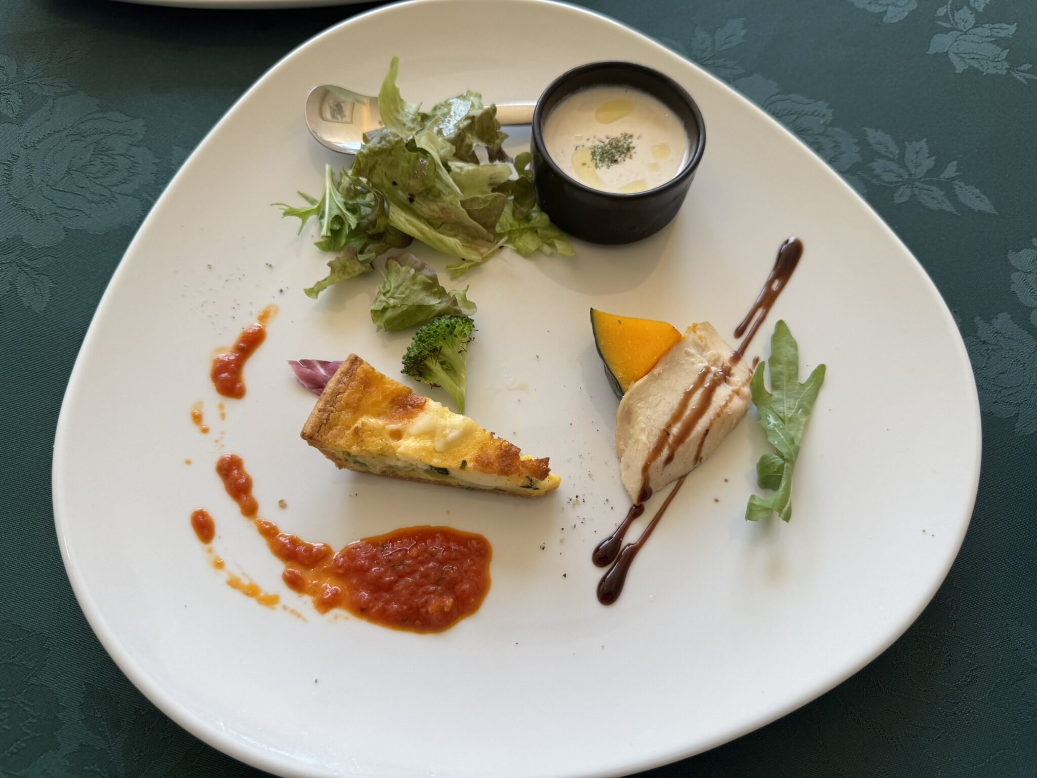 前菜の盛り合わせ（ごぼうのポタージュ、ほうれん草と白身魚のキッシュ、蒸し鶏のような料理にバルサミコソース）の写真